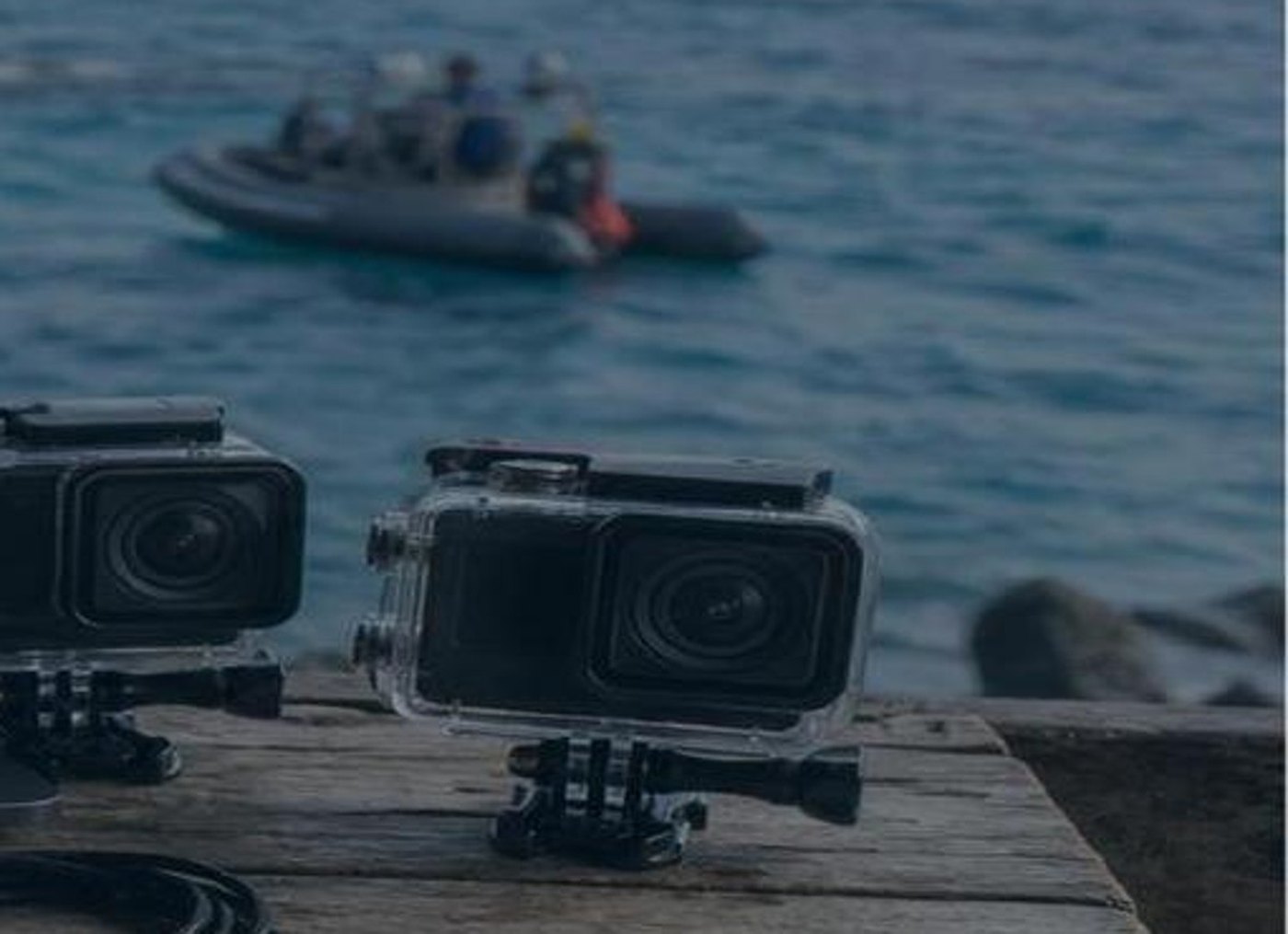 Field camera kit and editing laptop near the ocean
